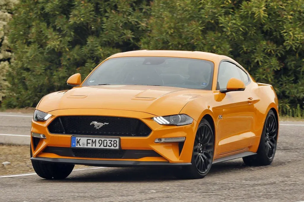 Ford Mustang der aktuellen Generation in Seitenansicht auf einer Straße, Motorhaube und Frontpartie gut sichtbar