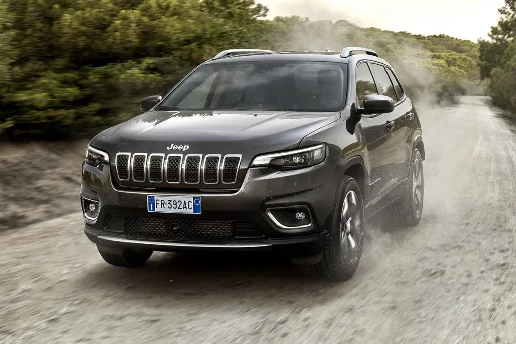 Jeep Grand Cherokee der aktuellen Generation auf einer Straße, fotografiert schräg von vorn in einem natürlichen Umfeld