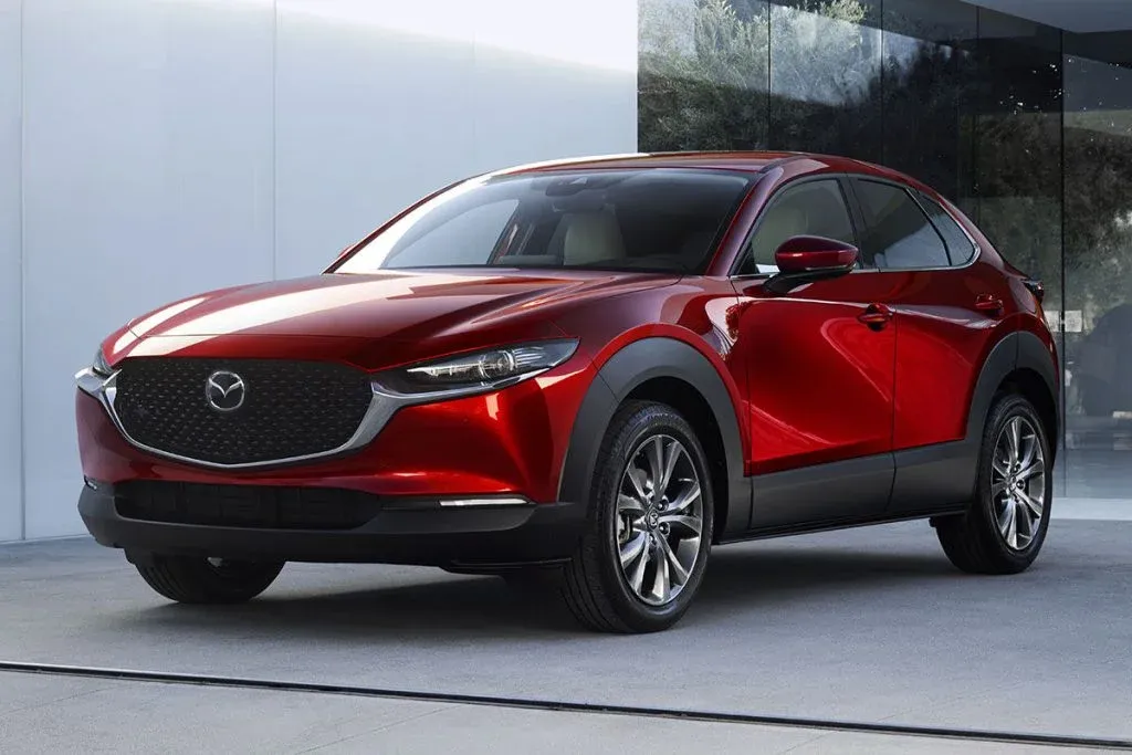 Mazda3 hatchback and Mazda CX-30 crossover parked on a modern road at sunset
