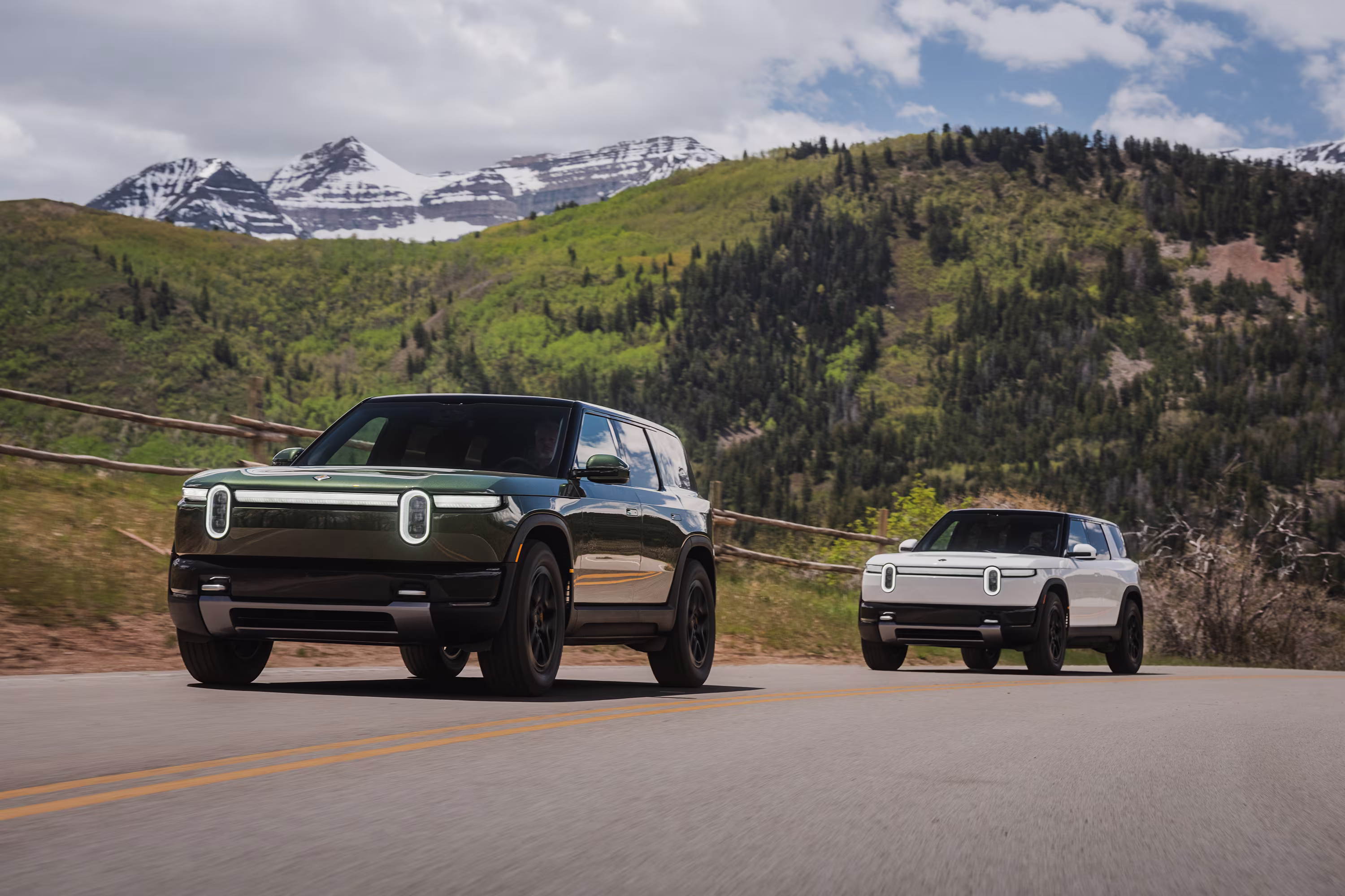 Rivian R1T und ein Volkswagen ID. Elektroauto stehen an einer modernen Ladestation vor einem Entwicklungszentrum